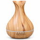 OKOS woodgrain-finish aroma diffuser with tulip-shaped opening and light band